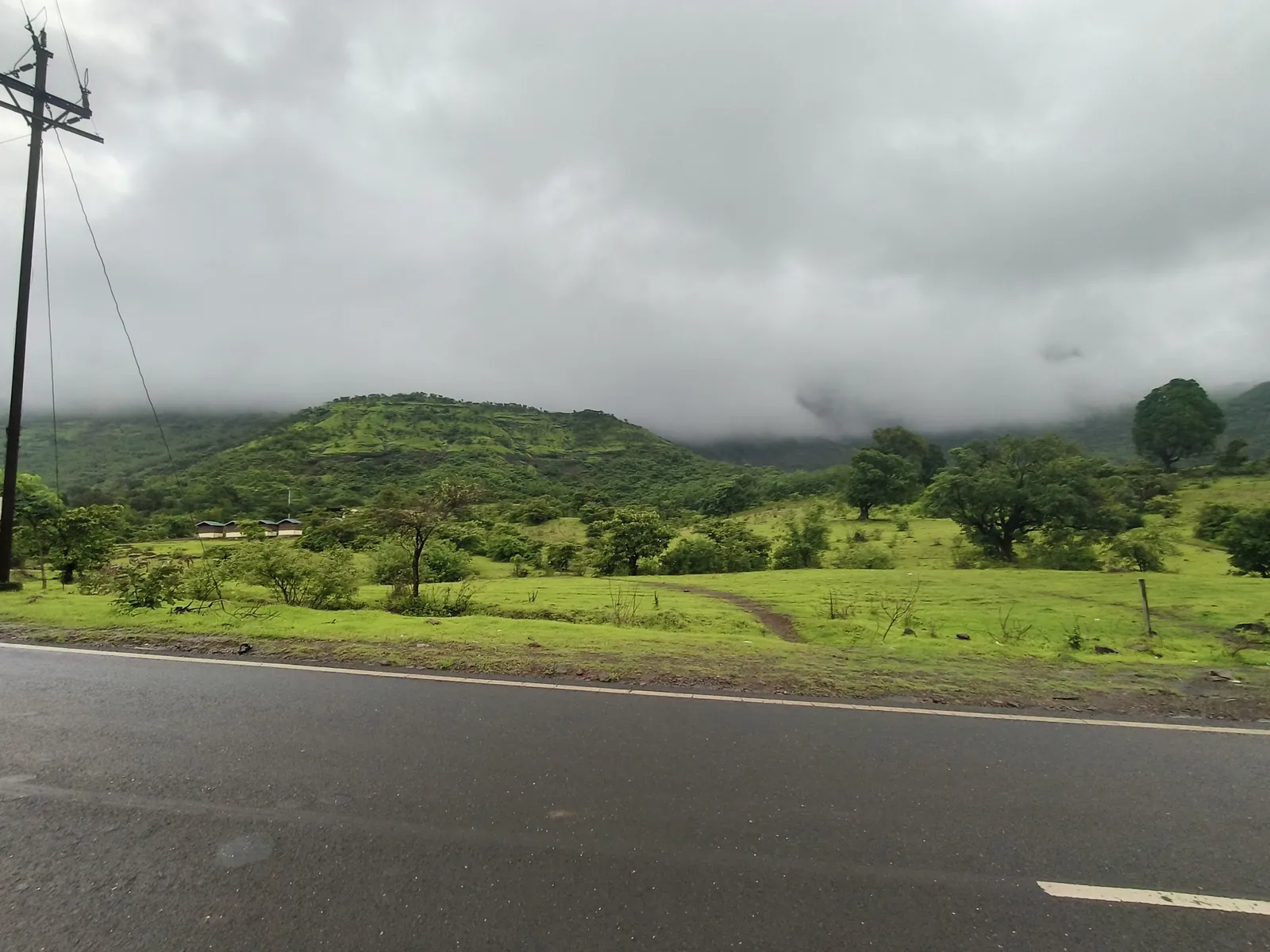 A monsoon highway through green hills, from the car