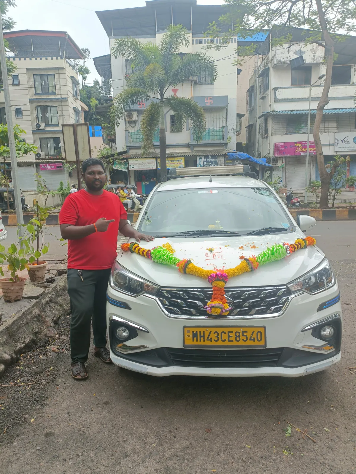 Rajkumar Rathore with the garlanded Ertiga outside the office lane
